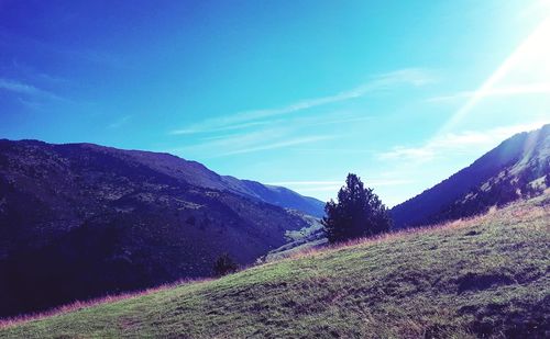 Scenic view of mountains against blue sky