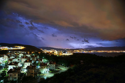 Illuminated buildings in city against sky at night