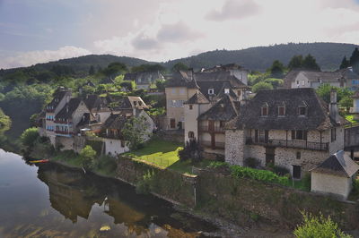 Houses by buildings against sky