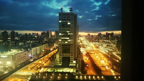 Illuminated cityscape against sky at night