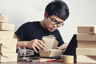 Full length of young man holding eyeglasses