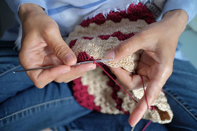 Craftsman is actively knitting using nylon yarn and knitting tools