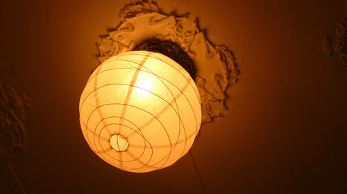 Low angle view of electric lamp in darkroom