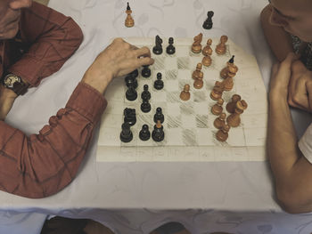 High angle view of grandfather and grandson playing chess on table