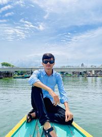 Man sitting in boat against sky