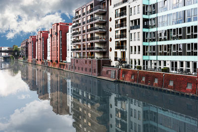 Reflection of buildings in canal against sky