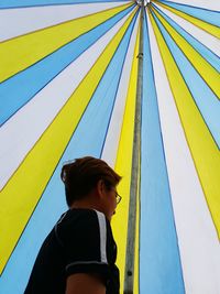 Low angle view of man looking away while standing inside tent