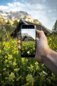 Cropped image of hand holding mobile phone