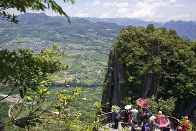 People over landscape against mountains and trees