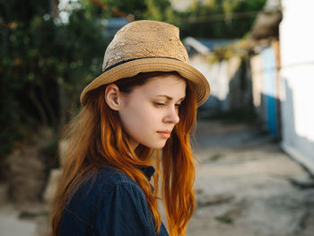 Portrait of young woman looking away outdoors
