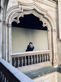 Portrait of young man standing against building