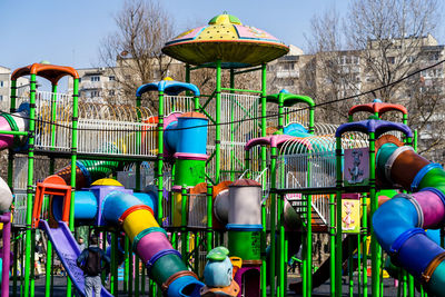 Multi colored chairs in park against sky