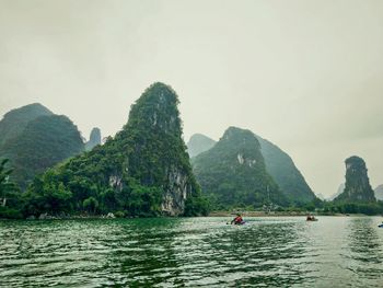 Scenic view of river with mountain range in background