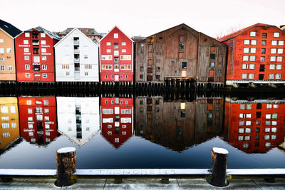 Canal amidst houses against sky during sunset