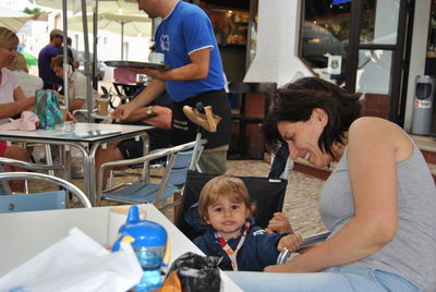 Portrait of son sitting with mother at outdoor cafe