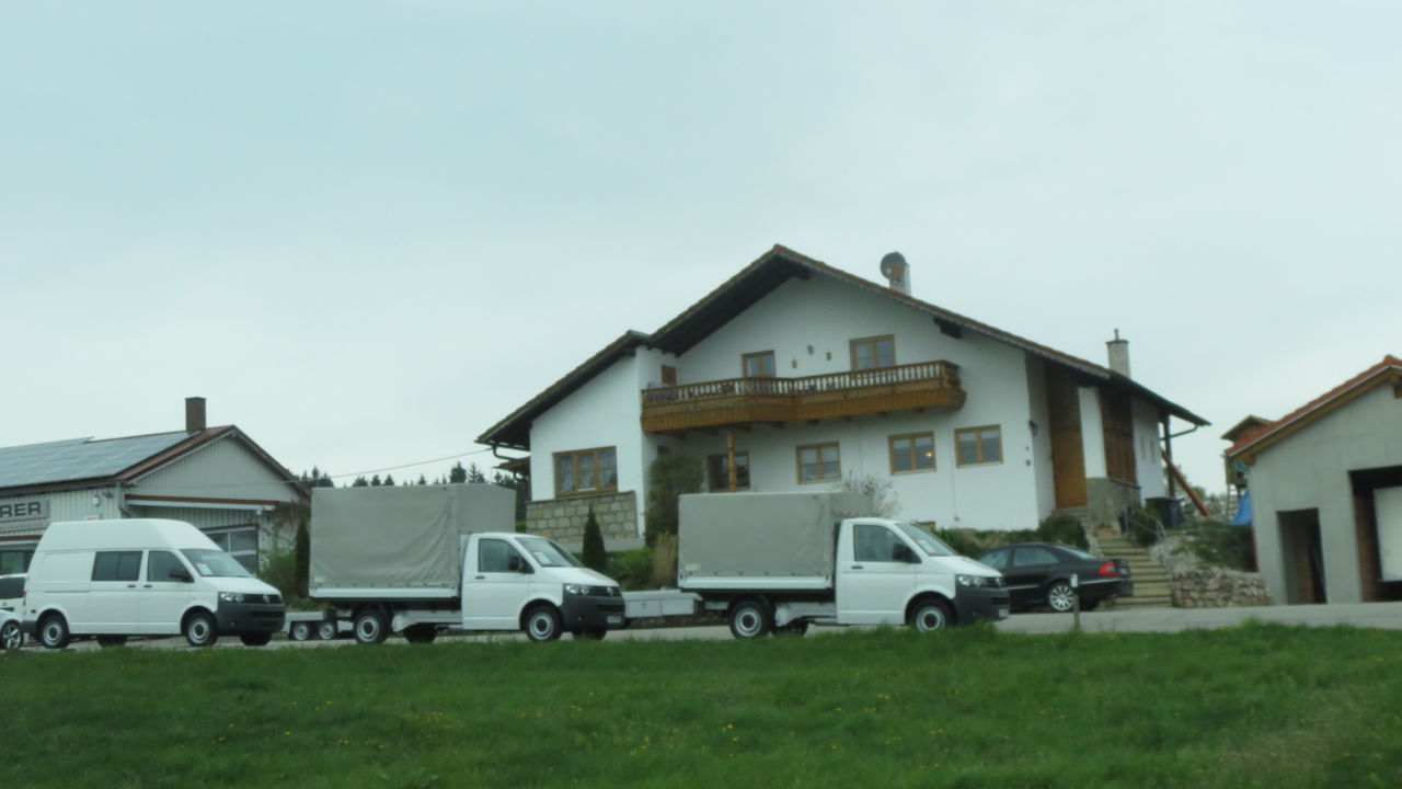 CARS ON HOUSES BY ROAD AGAINST SKY