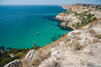 Boats and yachts in the crystal clear azure sea on a sunny day. cape fiolent in sevastopol.
