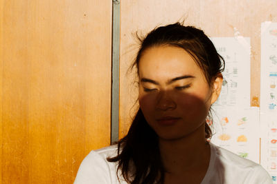 Close-up of young woman with eyes closed at home