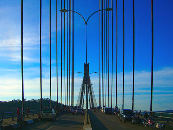 View of suspension bridge against cloudy sky