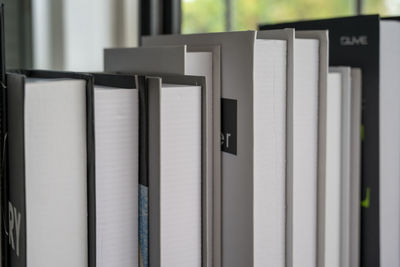 Hardcover books back edges on wooden shelves display of retail book store or shop over close up