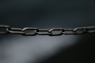Close-up of chain over black background