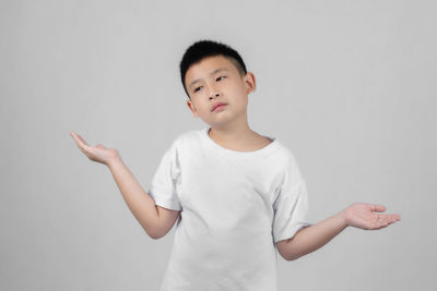 Cute boy standing against white background