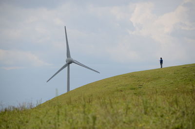 Low angle view of windmill on field against sky