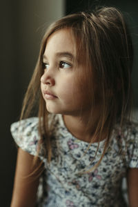 Girl looking out window with messy hair and brown eyes in buda texas