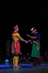 People in traditional clothing during festival at night