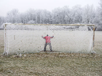 Man in soccer goal in winter