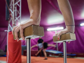 Cropped image of woman balancing on handstand canes at gym