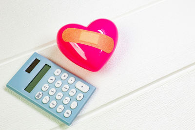 High angle view of heart shape on table against white wall