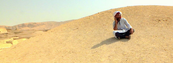 Portrait of young woman sitting on sand