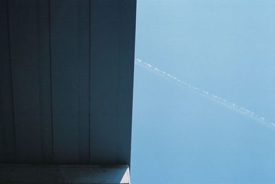 Low angle view of vapor trail against blue sky