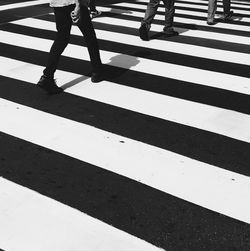 Low section of people walking on zebra crossing