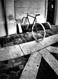 Bicycle parked against brick wall