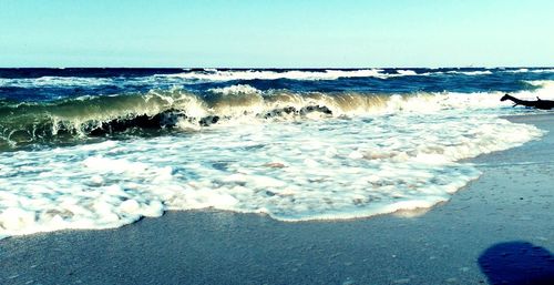 View of calm beach against clear sky