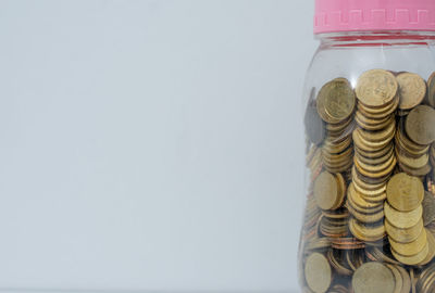 Close-up of coins in container against white background