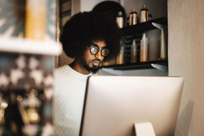 Young male hair expert working on computer in hair salon