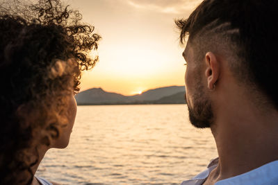 Close-up portrait of man by sea against sky during sunset