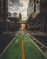 Road in city against cloudy sky