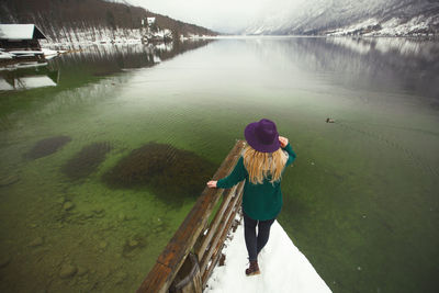 Rear view of woman standing in lake