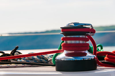 Close-up of rope tied to boat moored in sea against sky