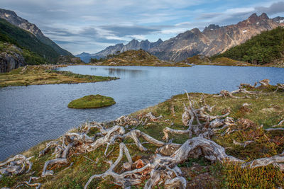 Scenic view of lake by mountains against sky