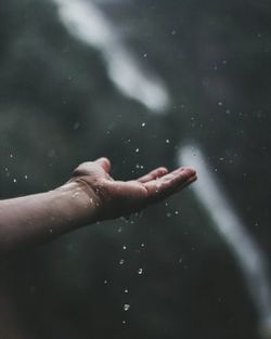 Cropped image of person hand on wet rainy season