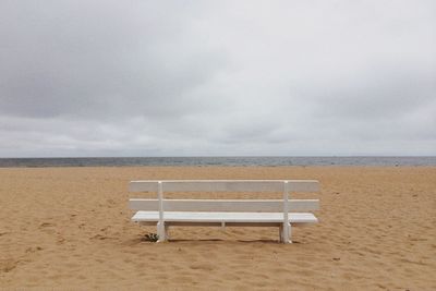 Scenic view of beach against cloudy sky