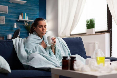 Woman sitting on table at home