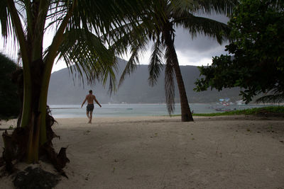 Man standing at beach against sky