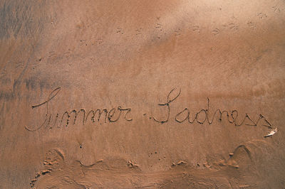 High angle view of text on sand at beach