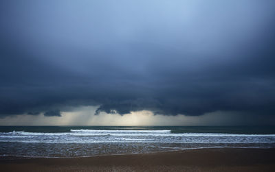 Scenic view of sea against storm clouds